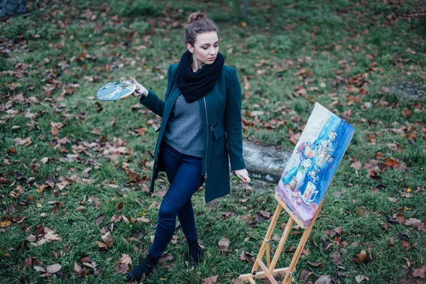 Genç kadın şövale içinde park arka plan üzerinde çizim — Stok fotoğraf