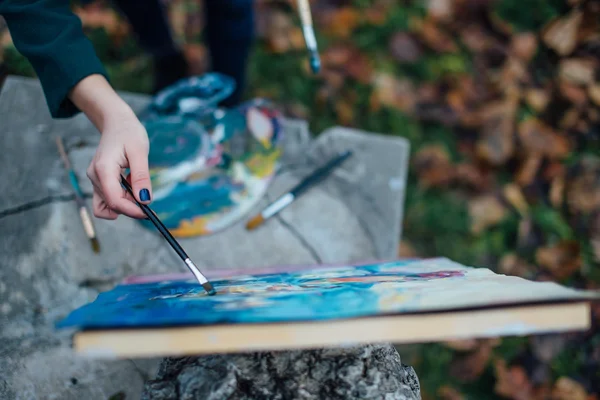 Mladá žena výkres v stojan na pozadí park — Stock fotografie