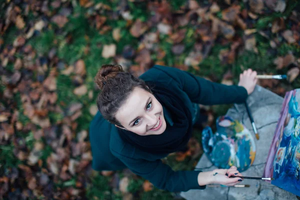 Jeune femme dessinant dans le chevalet sur le fond du parc — Photo