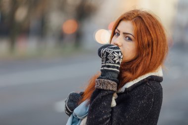 Red-haired girl standing on the street and laugh