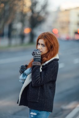 Red-haired girl standing on the street and laugh