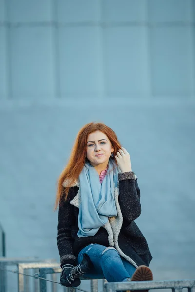 Young girl sitting on the metal bench near modern architecture — Zdjęcie stockowe