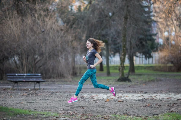 Nuori urheilu tyttö käynnissä puistossa — kuvapankkivalokuva