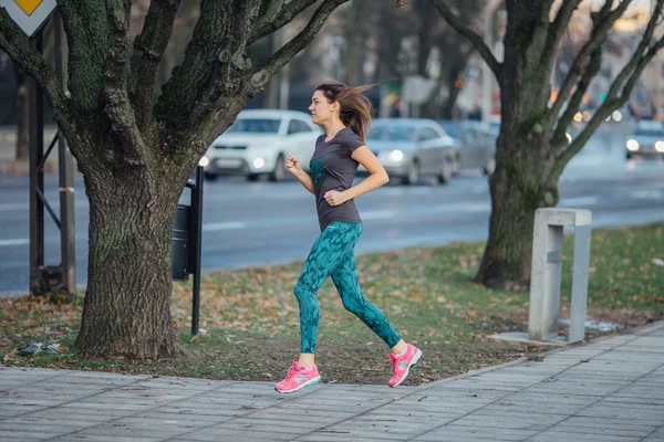 Jeune fille sportive qui court dans le parc — Photo