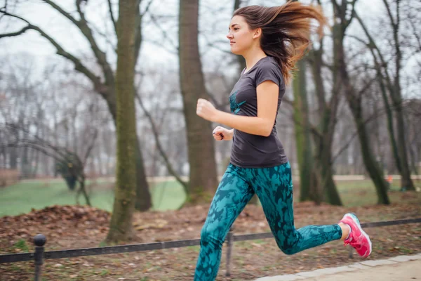 Jeune fille sportive qui court dans le parc — Photo