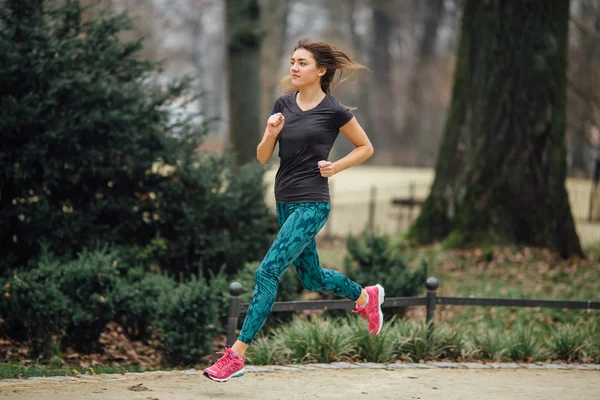 Jeune fille sportive qui court dans le parc — Photo