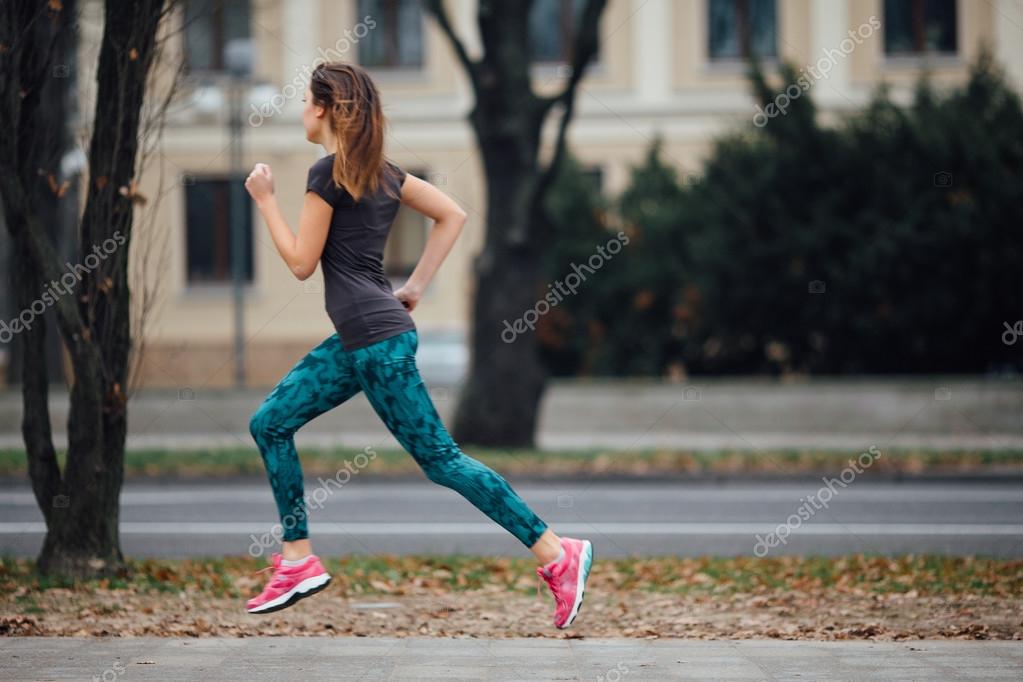 Young sport girl running in the park Stock Photo by ©SHipskyy 92208116