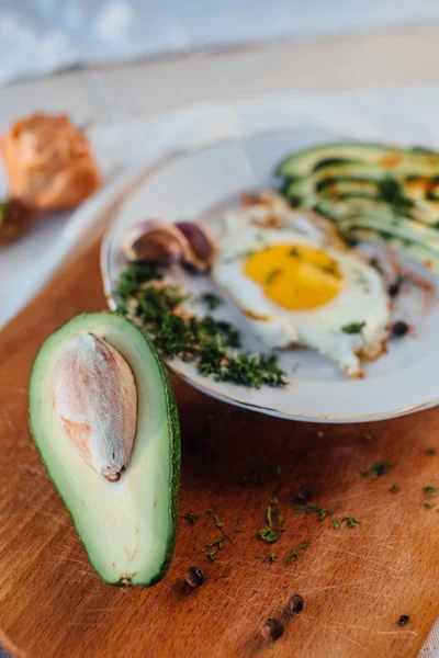 Frühstück mit Toast, Eiern, Avocado, Zwiebeln, Papier und Knoblauch — Stockfoto