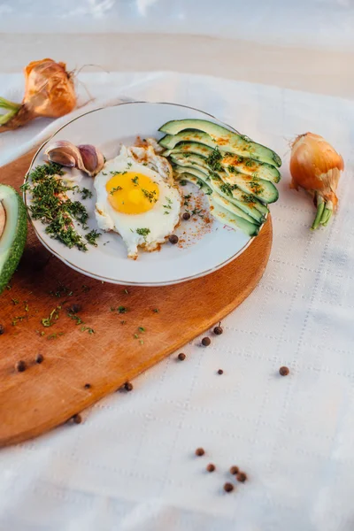 Desayuno compuesto por tostadas, huevos, aguacate, cebolla, papel y ajo — Foto de Stock