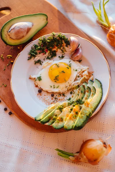 Desayuno compuesto por tostadas, huevos, aguacate, cebolla, papel y ajo — Foto de Stock