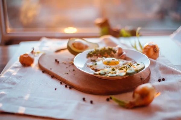 Desayuno compuesto por tostadas, huevos, aguacate, cebolla, papel y ajo — Foto de Stock