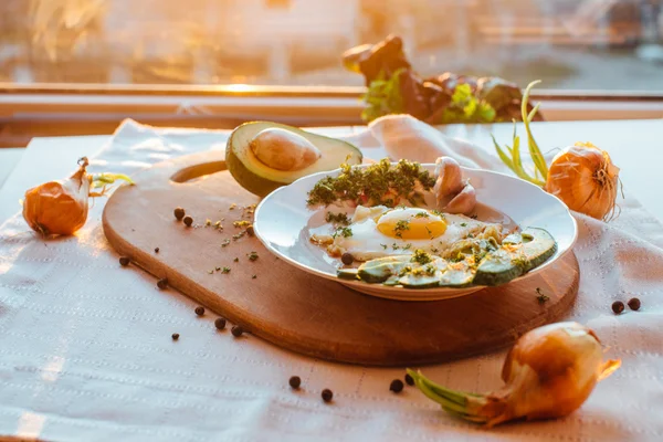 Desayuno compuesto por tostadas, huevos, aguacate, cebolla, papel y ajo — Foto de Stock