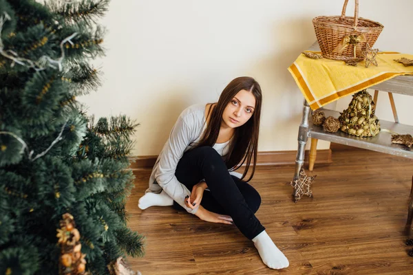 Seule fille assise derrière l'arbre de Noël avec des cadeaux — Photo