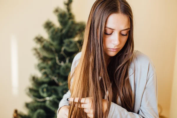 Seule fille assise derrière l'arbre de Noël avec des cadeaux — Photo