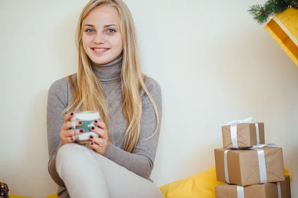 Blond jente drikker kaffe, spiser kjeks og leser en bok – stockfoto