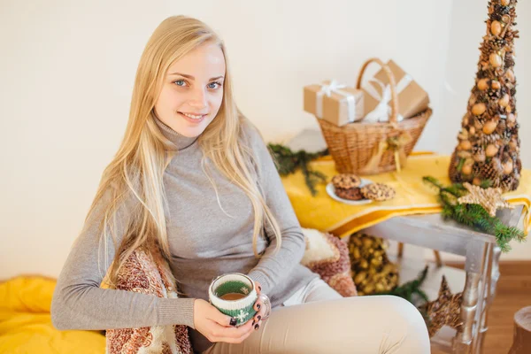 Blonde fille buvant son café, manger des cookies et lire un livre — Photo