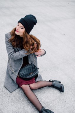 Sokakta oturan genç kadın.