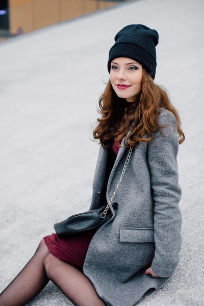 Jeune femme assise dans la rue — Photo