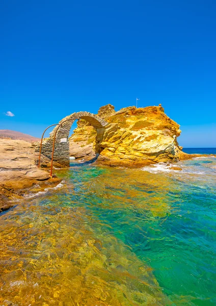 Красивый старый мост из камня в море на Chora — стоковое фото