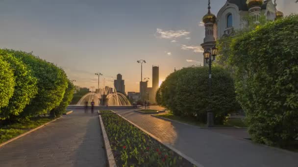 Beweging langs de laan met een fontein bij zonsondergang. Time-lapse (Hyper vervallen) — Stockvideo