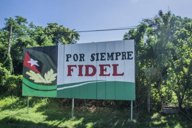Havana, Küba - 17 Temmuz 2018: Havana 'da büyük bir işaret açık mavi gökyüzü altında yemyeşil ile çevrili Por Siempre Fidel mesajını gösteriyor.
