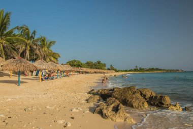 Trinidad, Küba - 17 Temmuz 2018: Güneşli sularda güneşlenen Trinidad sahilinde dinlenme ve keyif Küba 'da masmavi bir gökyüzünün altında palmiye ağaçları.