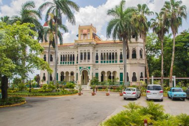 Cienfuegos, Küba - 14 Temmuz 2018: Güneşli bir günde Cienfuegos Küba 'da palmiye ağaçlarıyla çevrili büyük bir koloni binası karmaşık tasarımlar sergiliyor..