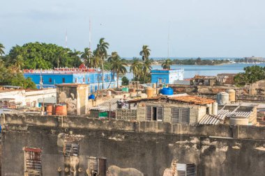 Cienfuegos, Küba - 14 Temmuz 2018: Cienfuegos 'taki eski binaların çatıları açık bir gökyüzünün altındaki palmiye ağaçları ile canlı renkler ve kıyı manzarası ortaya çıkarıyor.