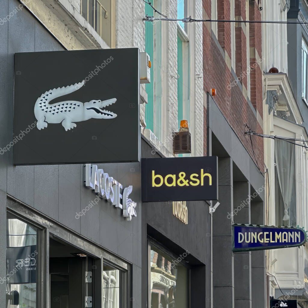 The hague, netherlands - may 02 2024: the entrance and logo on the facade at an outlet of the french retail chain Lacoste