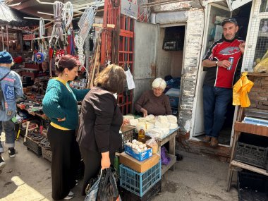 Telavi, Gürcistan - 26 Nisan 2025: Ziyaretçiler canlı Telavi pazarında taze ürün ve ürünlere göz atıyor ve yerel satıcılarla etkileşime giriyor ve bölgesel tatlar keşfediyor.
