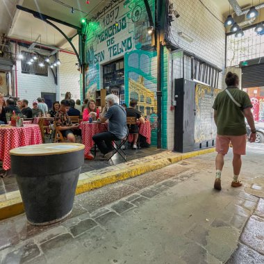 Buenos Aires, Arjantin - 29 Ekim 2022: İnsanlar çelik cam çatılı tarihi bir bina içinde büyük ve ünlü San Telmo gıda pazarını ziyaret edip yiyorlar.