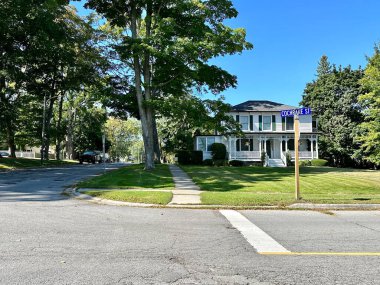 Port Perry, Kanada - 19 Eylül 2023: Tipik bir banliyö evi geniş bir bahçeye ve ağaçlarla çevrili davetkar bir verandaya sahiptir