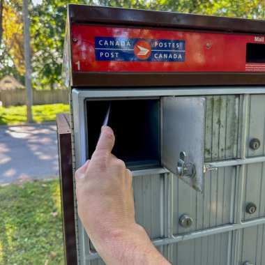 Port Perry, Kanada - 19 Eylül 2023: Kanada posta kutusunda bir kişi posta kutusunu açıyor.