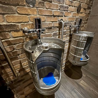 oshawa, Kanada - Eylül 06: 2023: Bir bar veya restoranın erkekler tuvaletindeki pisuarlar bira kutularından yapılır.