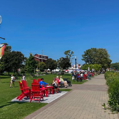 Port Perry, Kanada - 19 Ağustos 2023: İnsanlar rıhtım parkında sandalyelerde rahatça oturuyor ve koşup geçiyordu.