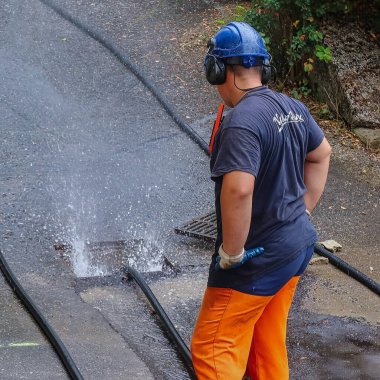 Menthon Saint Bernard, Fransa - 09 Eylül 2021: profesyonel bir işçi kanalizasyon borusunu temizlerken pompalı araba ve yüksek basınçlı hortumla meşgul