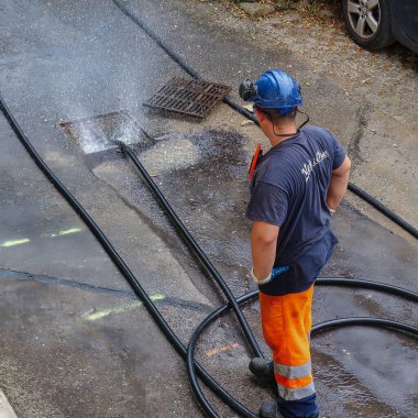 Menthon Saint Bernard, Fransa - 09 Eylül 2021: profesyonel bir işçi kanalizasyon borusunu temizlerken pompalı araba ve yüksek basınçlı hortumla meşgul