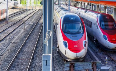 Cenevre, İsviçre - 08 Eylül 2022: Kırmızılı ve beyazlı İsviçreli modern trenler bir demiryolu istasyonunun yakınına park edilmiştir.