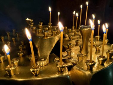 Mtskheta, Gürcistan - 25 Nisan 2025: Mtskheta 'daki Svetitskhoveli Katedrali' nin manevi atmosferini yükselten mumları yakan altın mum tutucular.