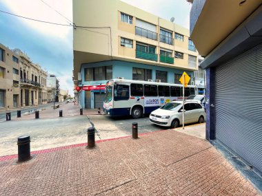 montevideo, uruguay - October 30 2022: A public transit bus is driving down the street in Ciudad Vieja Montevideo transporting a passenger through the historic area.