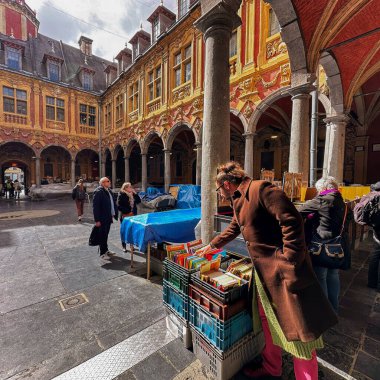 Lille, Fransa - 12 Nisan 2023: Avludaki insanlar tarihi eski kasabadaki eski borsada kitap tezgahları kurdular