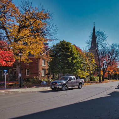 Gananoque, Kanada - 22 Ekim 2022: Sokakta arabası olan tarihi mimari kulesi olan bir Protestan kilisesi