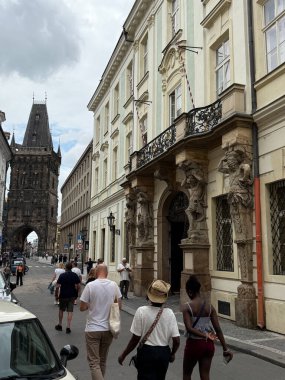 Prag, Çek Cumhuriyeti - 2 Haziran 2025: Prag Çek Cumhuriyeti 'nde turistler bulutlu bir günde Powder Tower' a doğru yürüyorlar. Binalar cadde hizasında..