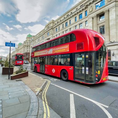 Londra, Birleşik Krallık - 6 Mart 2022: İnsanlar Viktorya dönemi binaları ve tipik İngiliz otobüsleriyle ünlü kral naibi caddesinde alışveriş yapıyorlar.