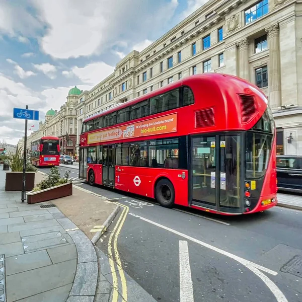 Londra, Birleşik Krallık - 6 Mart 2022: İnsanlar Viktorya dönemi binaları ve tipik İngiliz otobüsleriyle ünlü kral naibi caddesinde alışveriş yapıyorlar.