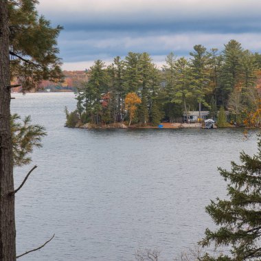 kawartha lakes, canada - 20 October 2022: a cabin on the shore of a small lake in the kawartha lakes region in fall colors