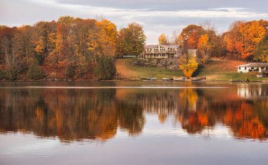 kawartha lakes, canada - 20 October 2022: a cabin on the shore of a small lake in the kawartha lakes region in fall colors