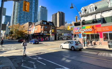 Toronto, Kanada - 24 Ekim 2022: Gay kilise sokağında scooter kullanan ve bar restoranları ve gay veya lgbtq kulüpleri olan bir kişi