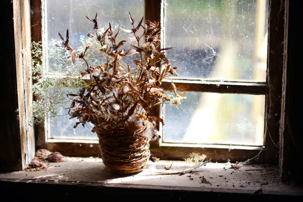 Korb mit getrockneten Blumen. Strauß getrockneter Blumen am Fenster im alten Haus. — Stockfoto