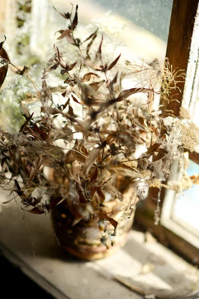 Korb mit getrockneten Blumen. Strauß getrockneter Blumen am Fenster im alten Haus. — Stockfoto